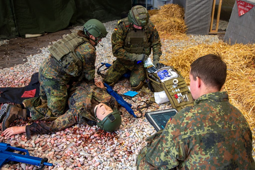 Unter dem kritischen Blick des Ausbilders Hauptfeldwebel Martin Rademacher trainieren zwei Unteroffizieranwärter des Sanitätsdienstes die taktische Verwundetenversorgung.