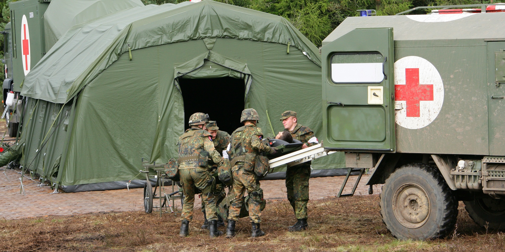 Medical Service: Delivery of a wounded person by ambulance (wheelchair) to an emergency station. Photo: German Armed Forces / Marcus Rott