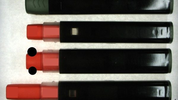 Abb. 1: Fotodarstellung der beiden Seitenansichten des in dieser Studie untersuchten Autoinjektors (lange Seite, kurze Seite) in seinen verschiedenen Zuständen: Die stabile Ausgabeform des Autoinjektors (oben), der auslösebereite Autoinjektor nach Abziehen der Kappe (Mitte) sowie der ausgelöste Autoinjektor nach Abschluss der Anwendung (unten). Der orangefarbene Nadelschutz umschließt die Nadel und verringert die Verletzungsgefahr. Das kennzeichnungslose, hochglänzende Etikett ist nur als Muster aufzufassen und stellt nicht den Endzustand dar. (Bildinhalte wurden aus patentrechtlichen Gründen teilweise unkenntlich gemacht)