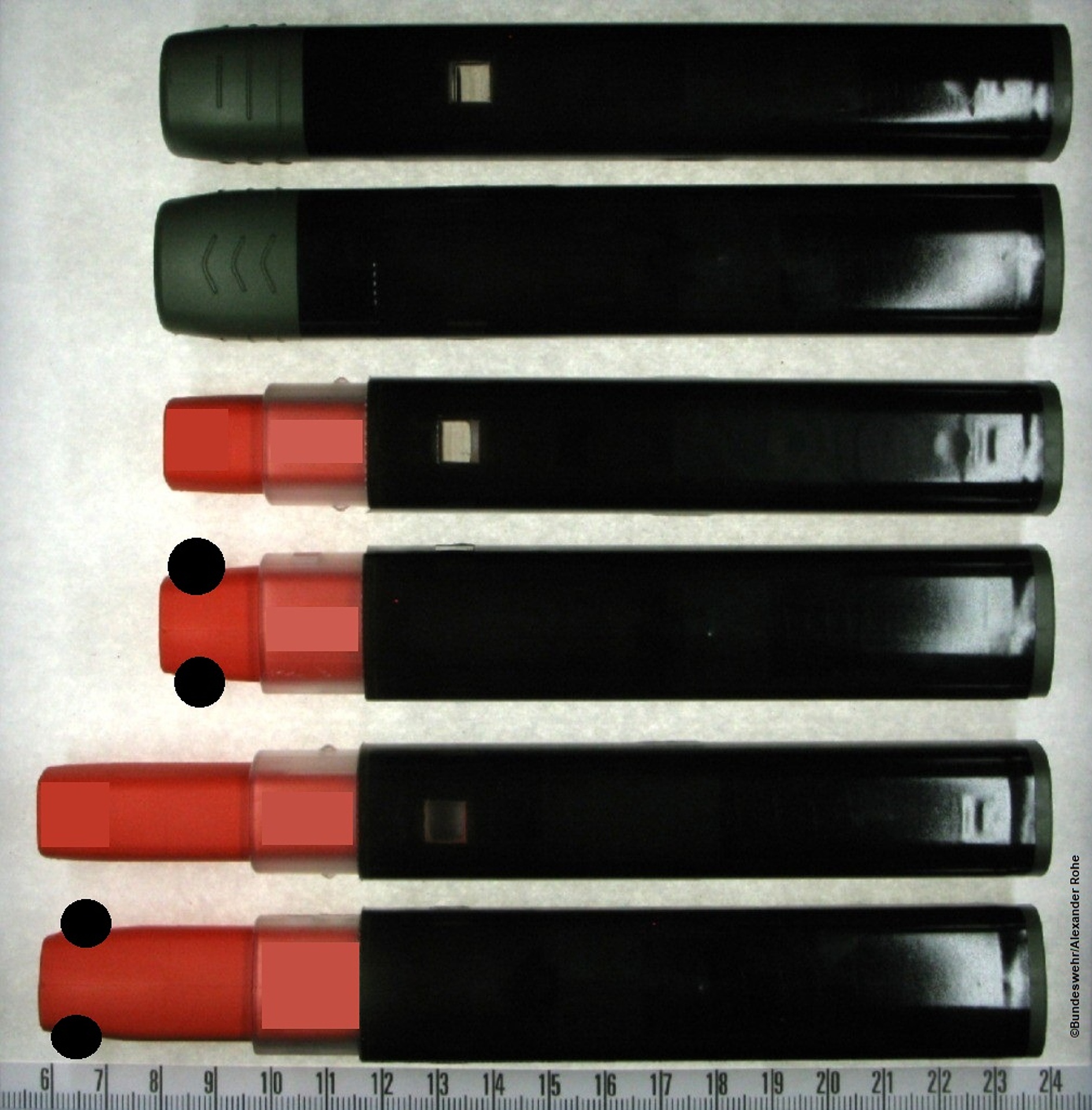 Abb. 1: Fotodarstellung der beiden Seitenansichten des in dieser Studie untersuchten Autoinjektors (lange Seite, kurze Seite) in seinen verschiedenen Zuständen: Die stabile Ausgabeform des Autoinjektors (oben), der auslösebereite Autoinjektor nach Abziehen der Kappe (Mitte) sowie der ausgelöste Autoinjektor nach Abschluss der Anwendung (unten). Der orangefarbene Nadelschutz umschließt die Nadel und verringert die Verletzungsgefahr. Das kennzeichnungslose, hochglänzende Etikett ist nur als Muster aufzufassen und stellt nicht den Endzustand dar. (Bildinhalte wurden aus patentrechtlichen Gründen teilweise unkenntlich gemacht)